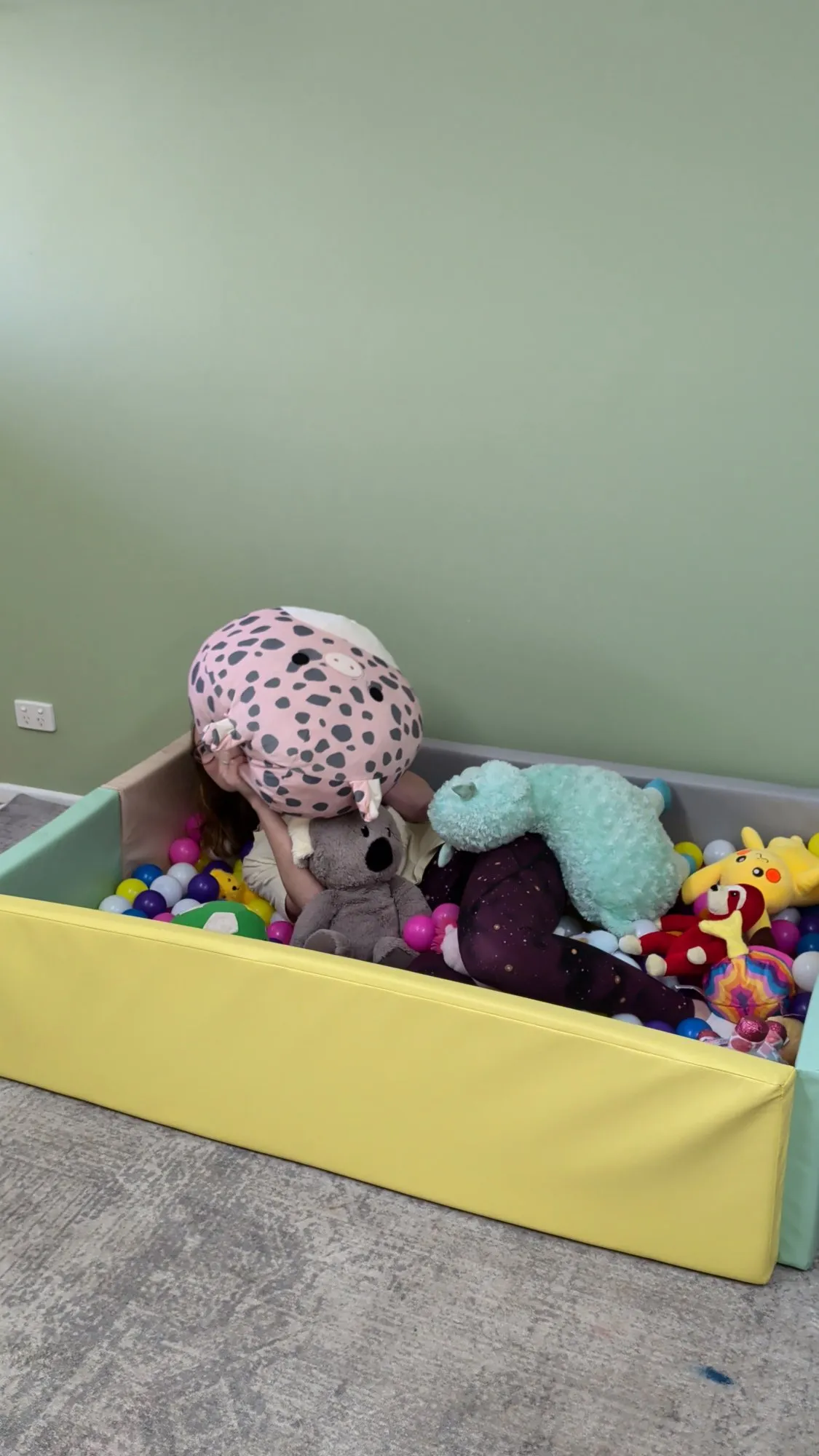 A soft ball pit full of plush toys
