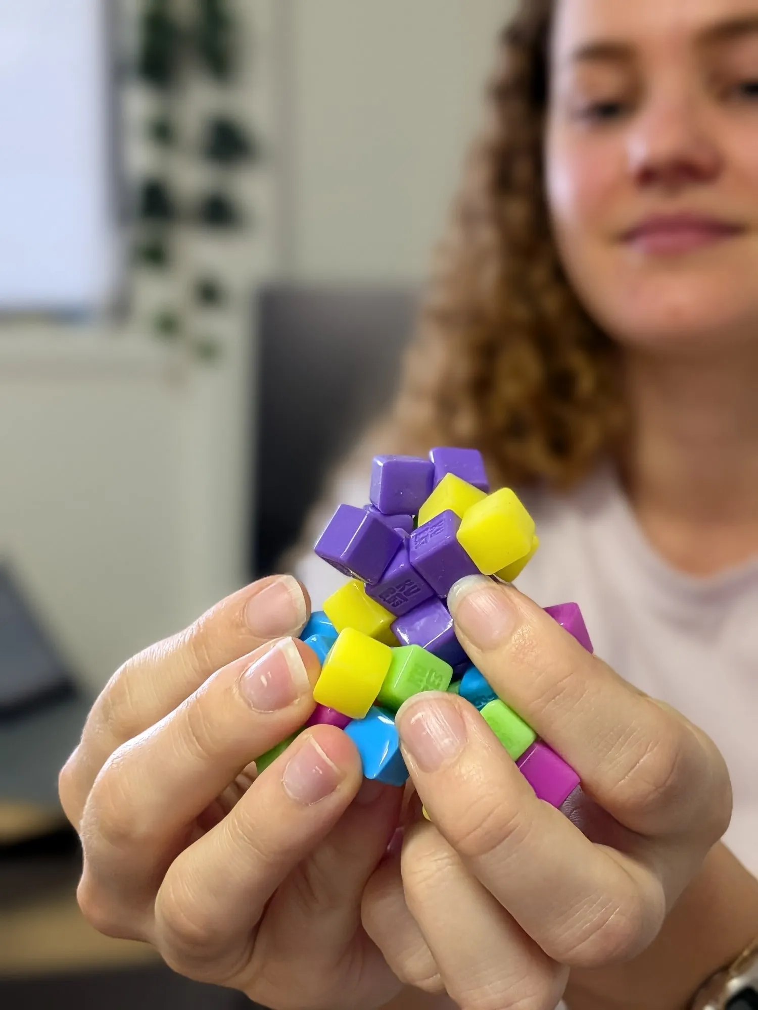 Hands holding a colourful fidget toy