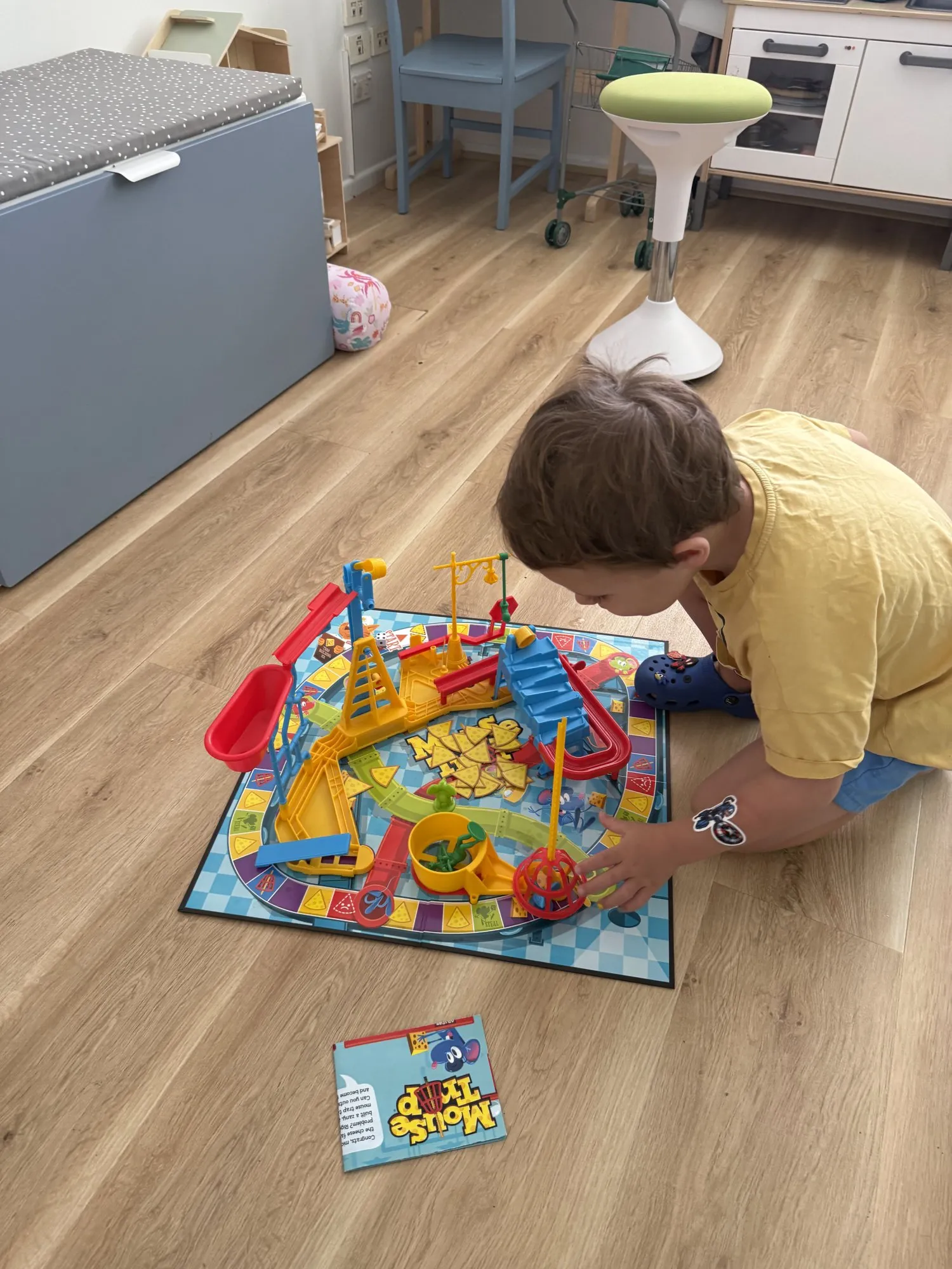 A child setting up a board game on the clinic floor