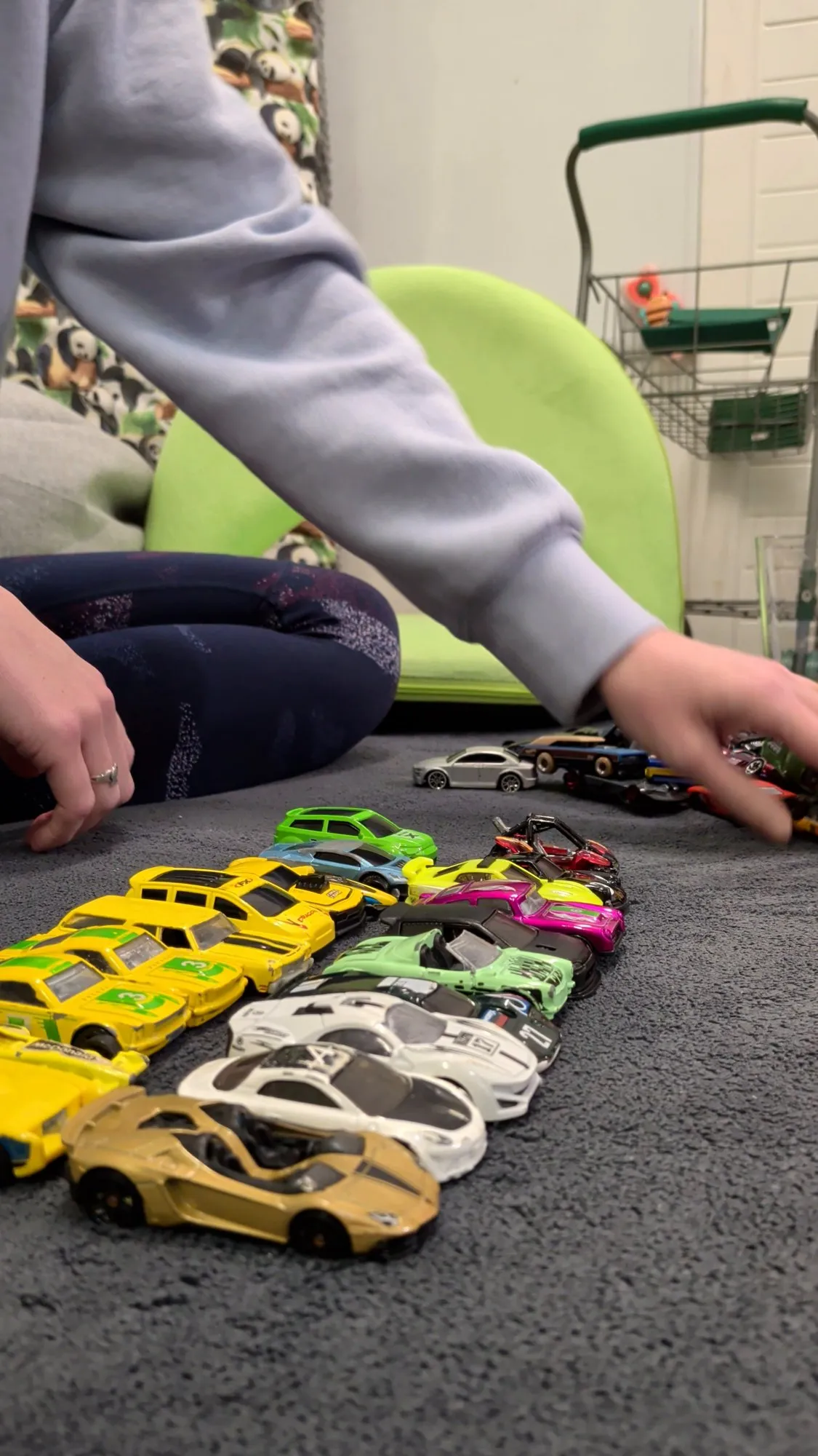 Toy cars lined up on the playroom mat